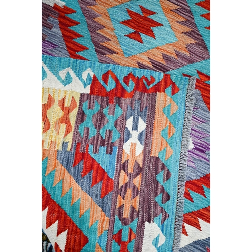 822 - An Anatolian kilim, the multi-coloured lozenge design on pale ground, 205 cm x 150 cm