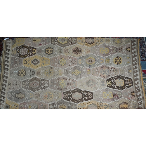 825 - An old Turkish kelim, the soft multi-coloured lozenge design on camel ground, 290 cm x 154 cm