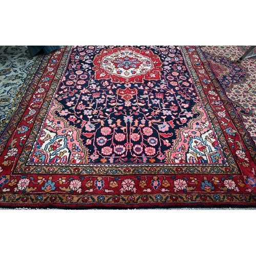 837 - A North West Persian Sarouk carpet, the red ground centred by a blue ground medallion and floral vin... 