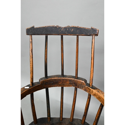857 - An 18th century oak/elm low spindle back Windsor armchair, West Country, raised on stick legs