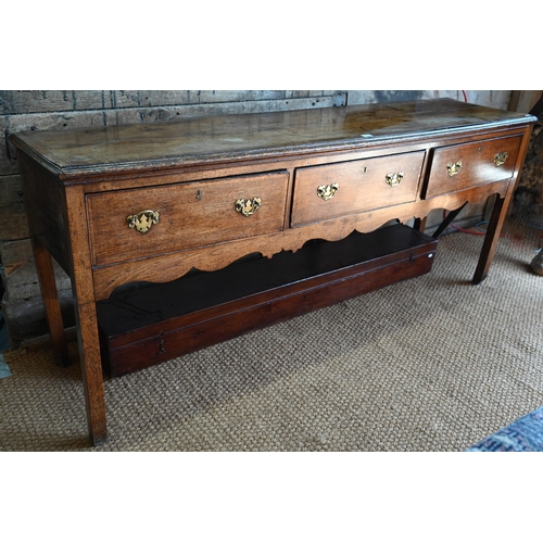 859 - A late 17th century oak three drawer low dresser, raised on square section legs, later brass handles... 