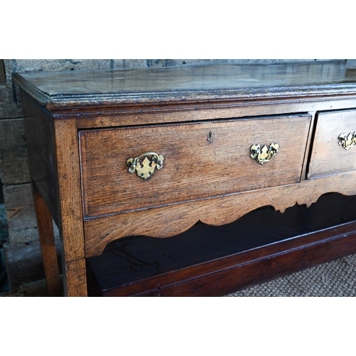 859 - A late 17th century oak three drawer low dresser, raised on square section legs, later brass handles... 