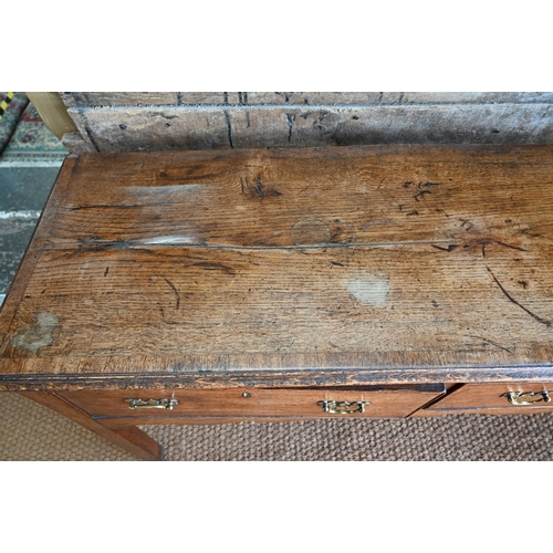 859 - A late 17th century oak three drawer low dresser, raised on square section legs, later brass handles... 