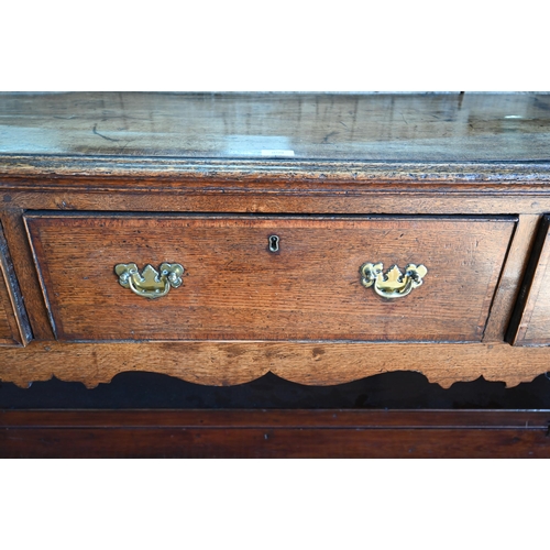 859 - A late 17th century oak three drawer low dresser, raised on square section legs, later brass handles... 
