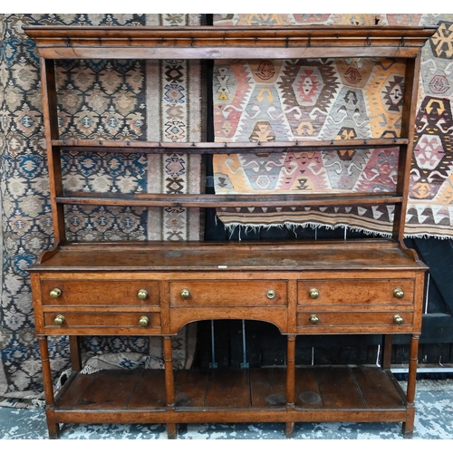 875 - An 18th century oak high dresser, the open back three tier rack with iron hooks, over an arrangement... 