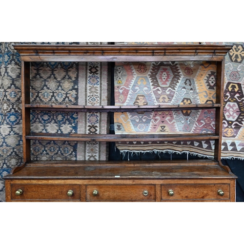 875 - An 18th century oak high dresser, the open back three tier rack with iron hooks, over an arrangement... 