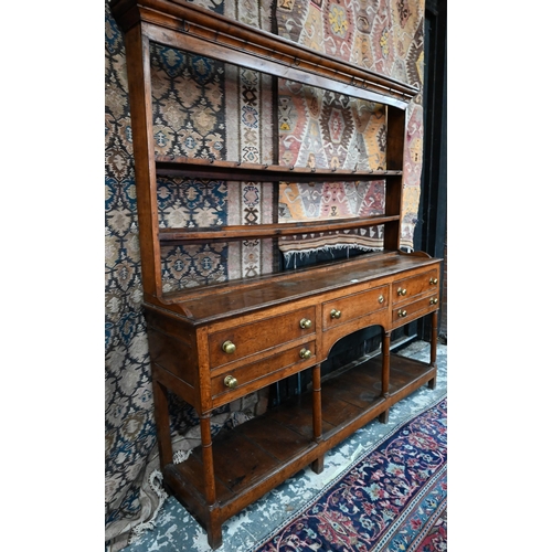 875 - An 18th century oak high dresser, the open back three tier rack with iron hooks, over an arrangement... 