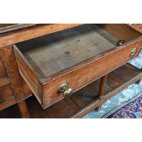 875 - An 18th century oak high dresser, the open back three tier rack with iron hooks, over an arrangement... 