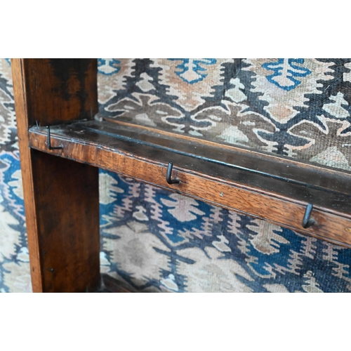 875 - An 18th century oak high dresser, the open back three tier rack with iron hooks, over an arrangement... 