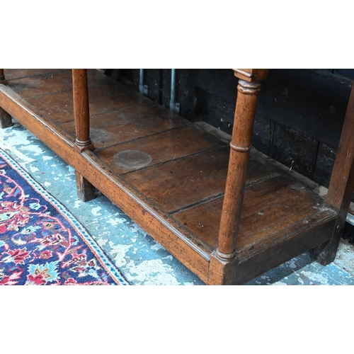 875 - An 18th century oak high dresser, the open back three tier rack with iron hooks, over an arrangement... 