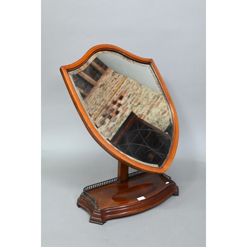 876 - A large Victorian Sheraton Revival mahogany framed adjustable shield shaped toilet mirror, with beve... 