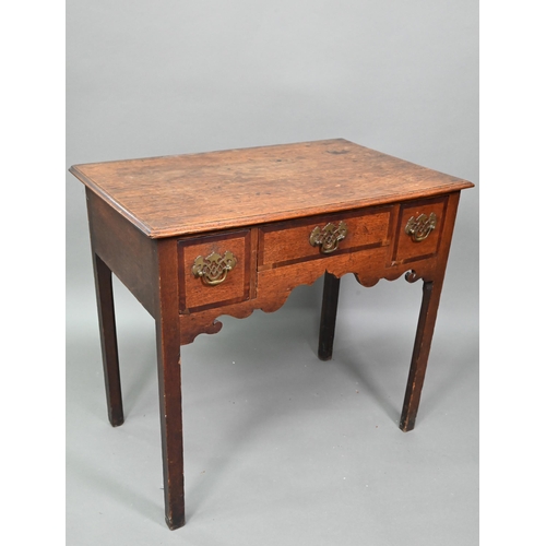 878 - A Georgian country oak three drawer lowboy, raised on inner chamfered square legs, later brass fitti... 