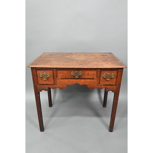 878 - A Georgian country oak three drawer lowboy, raised on inner chamfered square legs, later brass fitti... 