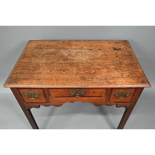 878 - A Georgian country oak three drawer lowboy, raised on inner chamfered square legs, later brass fitti... 