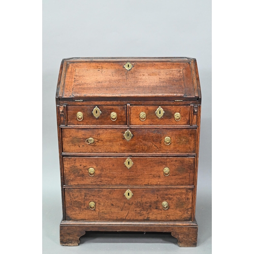 884 - A mid 18th oak bureau of diminutive proportions, the interior with basic drawers and niches over fou... 