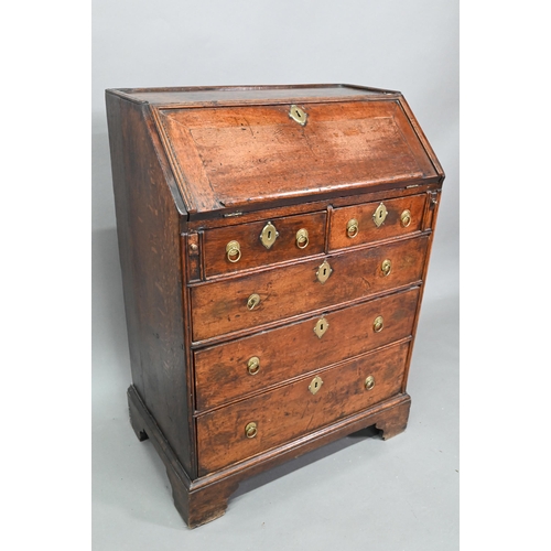 884 - A mid 18th oak bureau of diminutive proportions, the interior with basic drawers and niches over fou... 