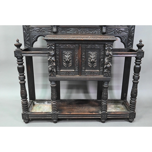 887 - A Victorian carved oak mirror backed hall stand, with cupboard and twin stick stands, 119 cm w x 39 ... 