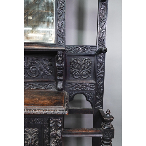 887 - A Victorian carved oak mirror backed hall stand, with cupboard and twin stick stands, 119 cm w x 39 ... 