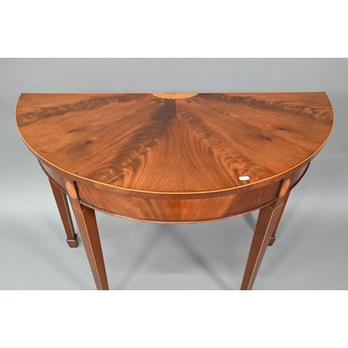 888 - A pair of boxwood inlaid figured mahogany Sheraton Revival demi-lune tables, raised on square taperi... 