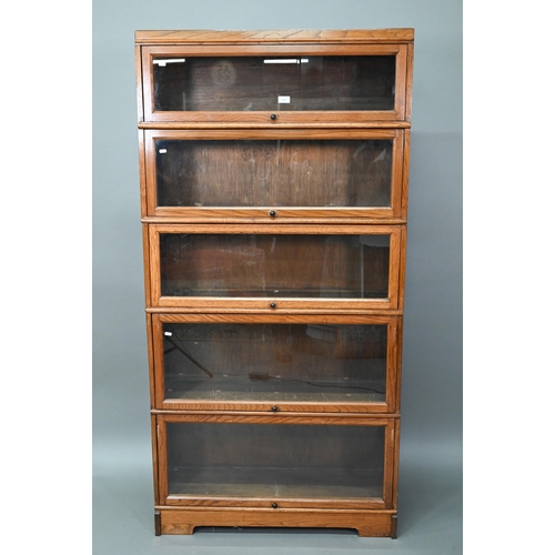 896 - Fandson, London, a five tier golden oak five section library bookcase, with glazed-in hinge-over doo... 