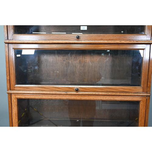 896 - Fandson, London, a five tier golden oak five section library bookcase, with glazed-in hinge-over doo... 