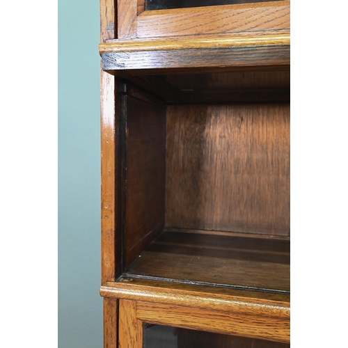 896 - Fandson, London, a five tier golden oak five section library bookcase, with glazed-in hinge-over doo... 