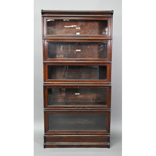 897 - A dark oak five section Globe Wernicke library bookcase, with glazed-in hinge-over doors, on a plint... 