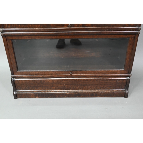 897 - A dark oak five section Globe Wernicke library bookcase, with glazed-in hinge-over doors, on a plint... 