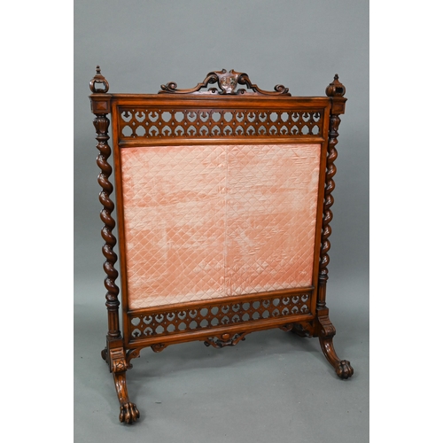 905 - A Victorian mahogany framed fire screen with polychrome armorial device to the crest rail, over a fa... 