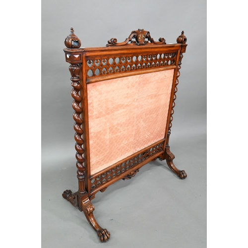 905 - A Victorian mahogany framed fire screen with polychrome armorial device to the crest rail, over a fa... 