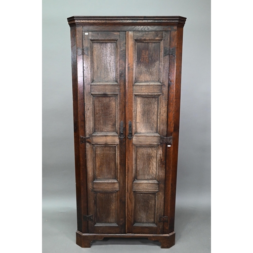 907 - An 18th century and later composed tall oak corner cupboard, with pair of panelled doors enclosing s... 