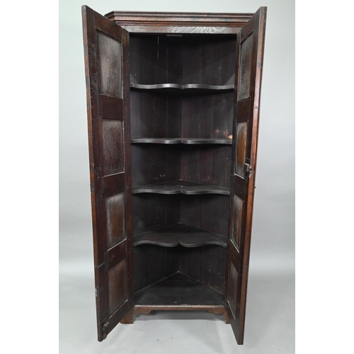 907 - An 18th century and later composed tall oak corner cupboard, with pair of panelled doors enclosing s... 