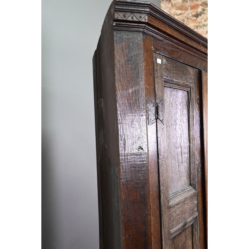 907 - An 18th century and later composed tall oak corner cupboard, with pair of panelled doors enclosing s... 