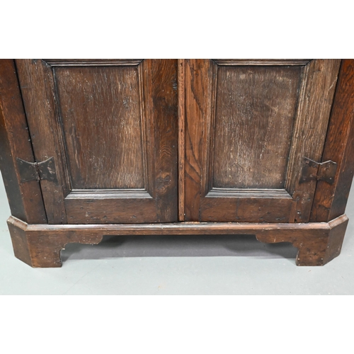 907 - An 18th century and later composed tall oak corner cupboard, with pair of panelled doors enclosing s... 