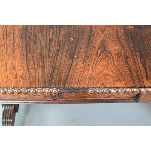 922 - A Regency rosewood sofa/library table, the rectangular top with beaded edge and rounded drop leaf en... 