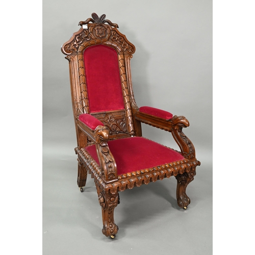 928 - A carved and moulded oak framed 'throne' chair, with crimson fabric panelled back and seat, the vers... 