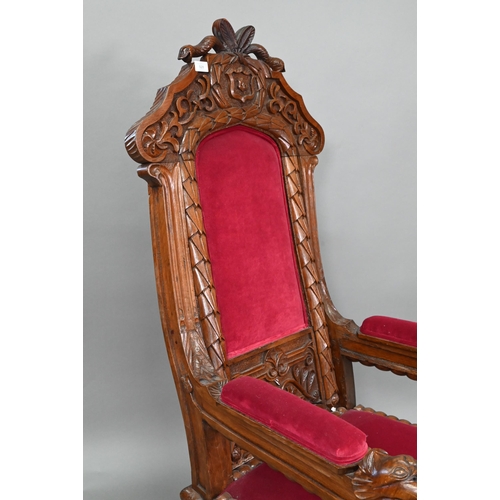 928 - A carved and moulded oak framed 'throne' chair, with crimson fabric panelled back and seat, the vers... 