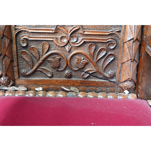 928 - A carved and moulded oak framed 'throne' chair, with crimson fabric panelled back and seat, the vers... 