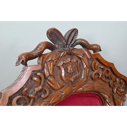 928 - A carved and moulded oak framed 'throne' chair, with crimson fabric panelled back and seat, the vers... 