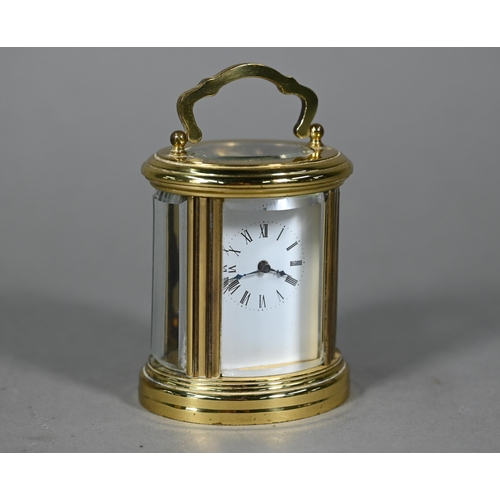 961 - A lacquered brass oval cased carriage clock, the 8-day movement with white enamelled dial, 9 cm h