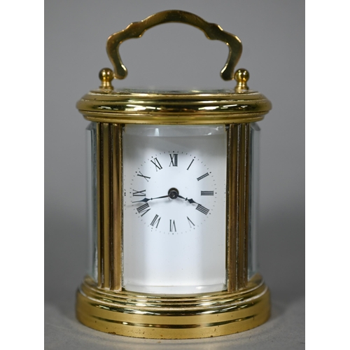 961 - A lacquered brass oval cased carriage clock, the 8-day movement with white enamelled dial, 9 cm h