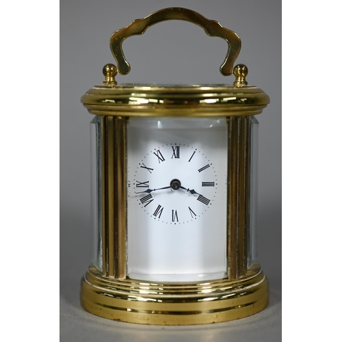 961 - A lacquered brass oval cased carriage clock, the 8-day movement with white enamelled dial, 9 cm h