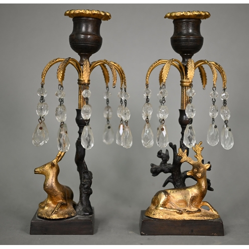 1166 - A pair of Empire period bronze and gilt candlesticks, with palm-fronds suspended with glass bead dro... 