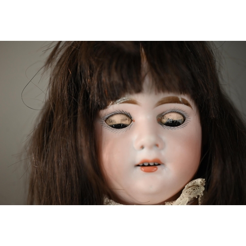 1195 - An Armand Marseille no 3500 AM 2 1/2D bisque-headed girl doll with brown wig, closing brown eyes and... 