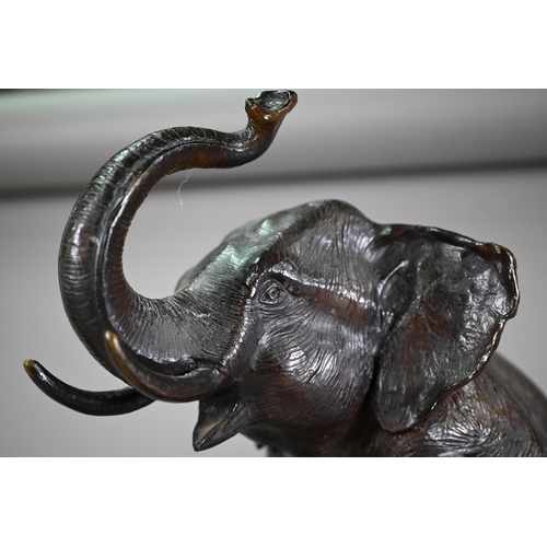 1206 - A cast patinated dark bronze sculpture after A Barye, a trumpeting elephant raised on a globe - on a... 