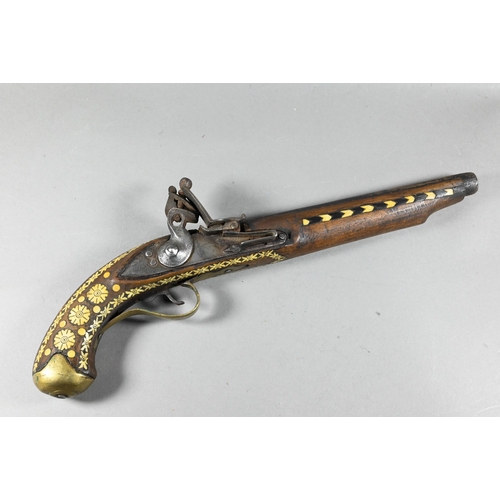 1068 - An Indo-Persian flintlock pistol with 25 cm barrel, the walnut fullstock richly inlaid with bone and... 