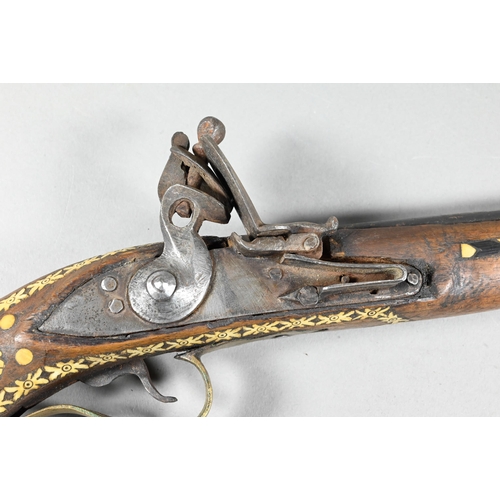 1068 - An Indo-Persian flintlock pistol with 25 cm barrel, the walnut fullstock richly inlaid with bone and... 