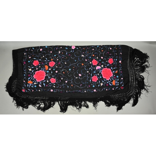 1125 - A circa 1930s Chinese silk 'piano' shawl, the black ground profusely decorated with flowers in colou... 