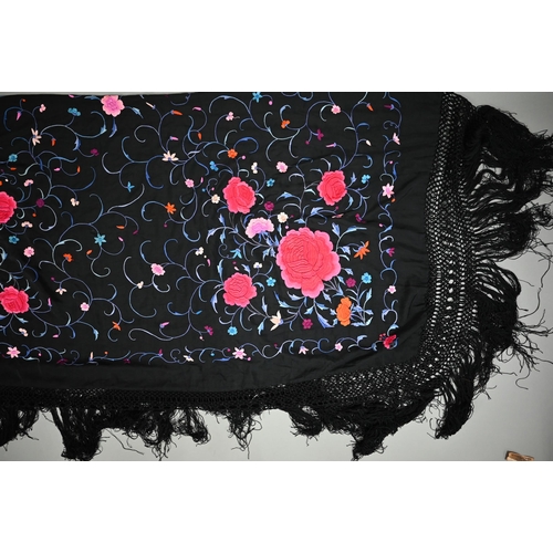 1125 - A circa 1930s Chinese silk 'piano' shawl, the black ground profusely decorated with flowers in colou... 