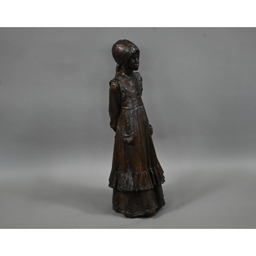 1210 - A bronzed pottery sculpture of a young woman, standing, in a long dress, 77 cm h